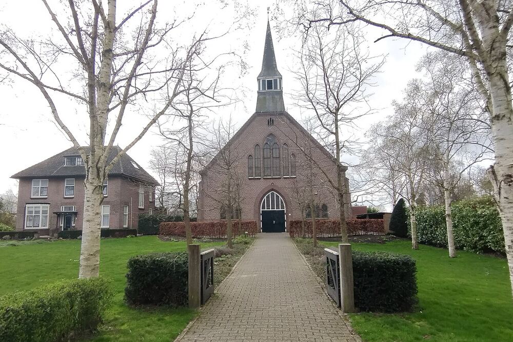 De Gereformeerde Kerk van Krabbendijke aan het eind van een pad met bomen